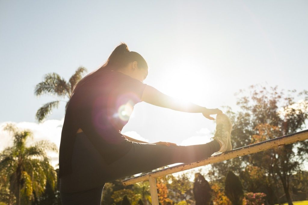 woman stretching against fence