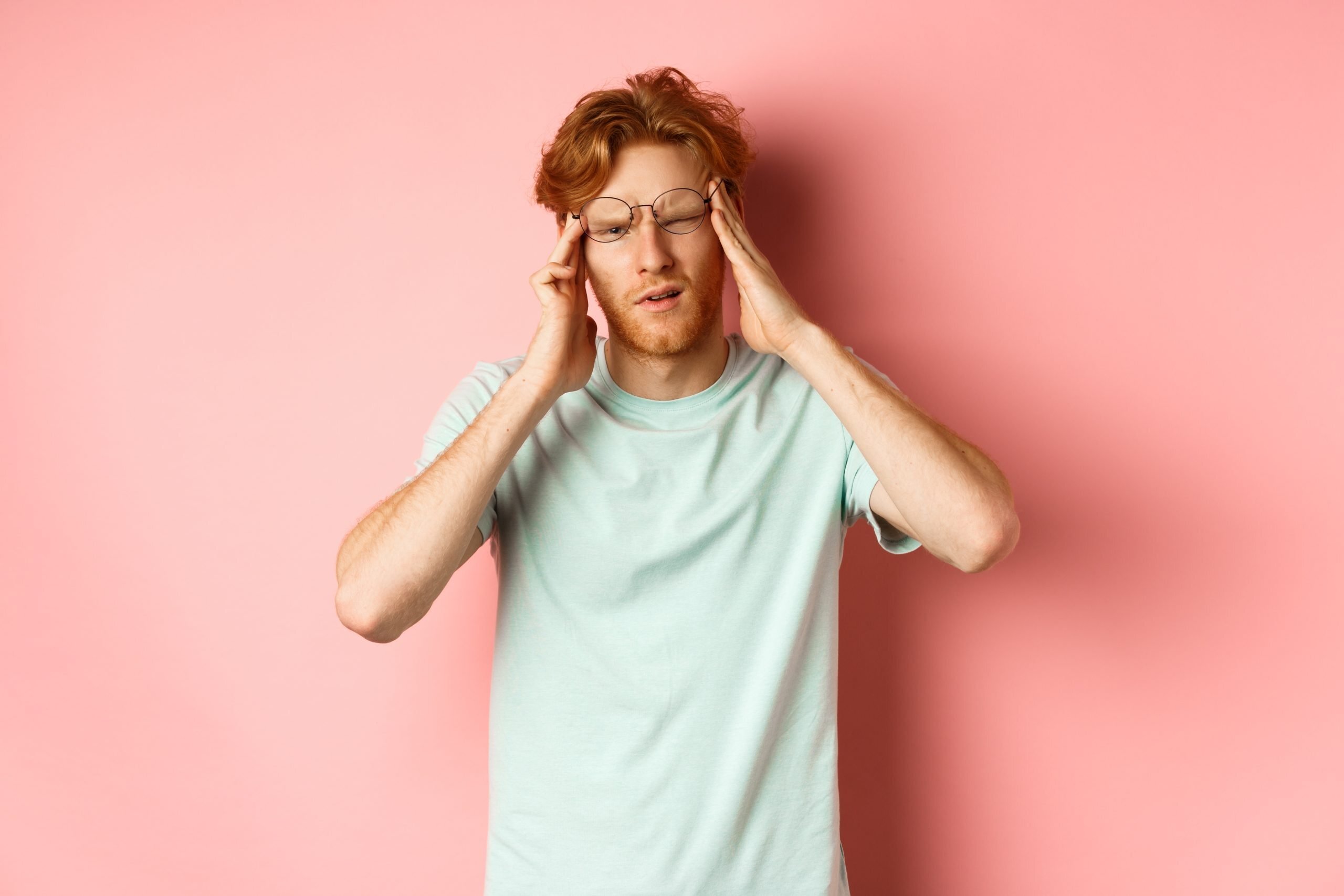 portrait redhead man crooked glasses touching head feeling dizzy nauseous having hangover headache standing pink background scaled Top 10 Symptoms of Whiplash