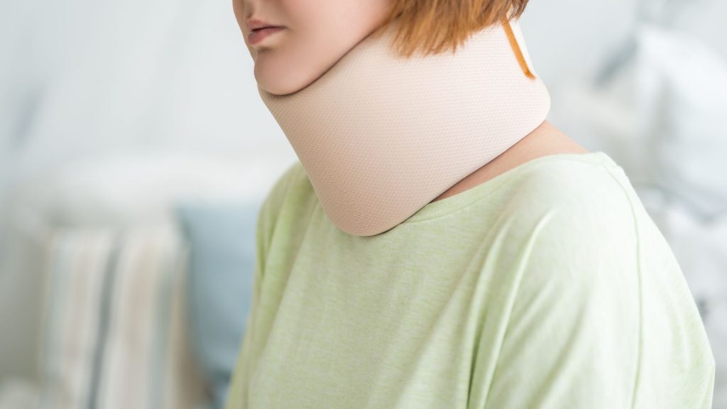 Close-up of a woman wearing a neck brace, recovering from an injury.