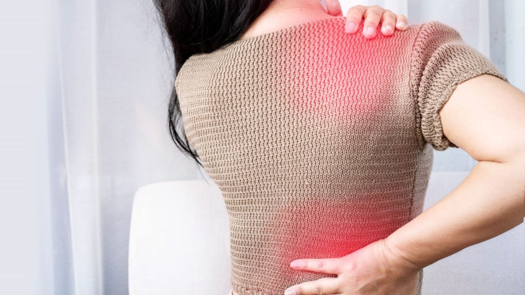 Woman holding her neck and lower back, with red highlights showing muscle tension.