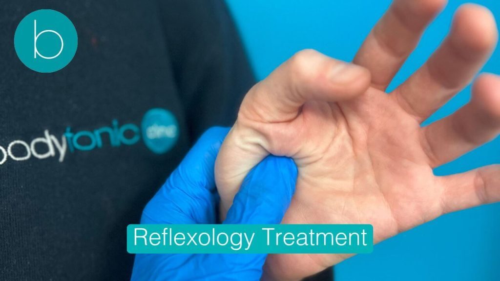 A reflexologist performing hand reflexology by applying firm pressure to the palm of a patient.