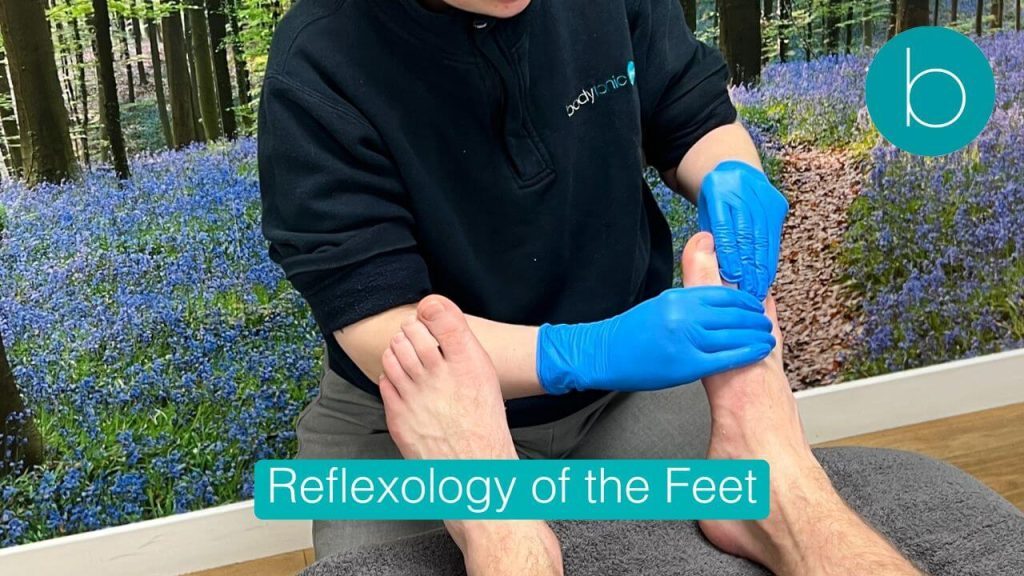 Professional reflexologist applying pressure to a patient's foot during a treatment session at Bodytonic Clinic.
